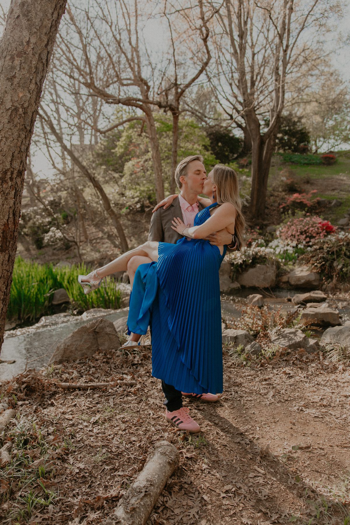 Ian carrying Kimberly for a kiss beside a garden stream
