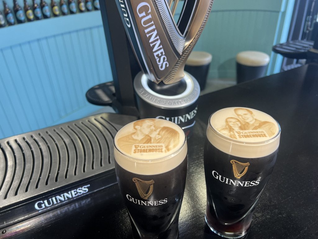 Two pints of Guinness with Kimberly and Ian's faces printed in the foam