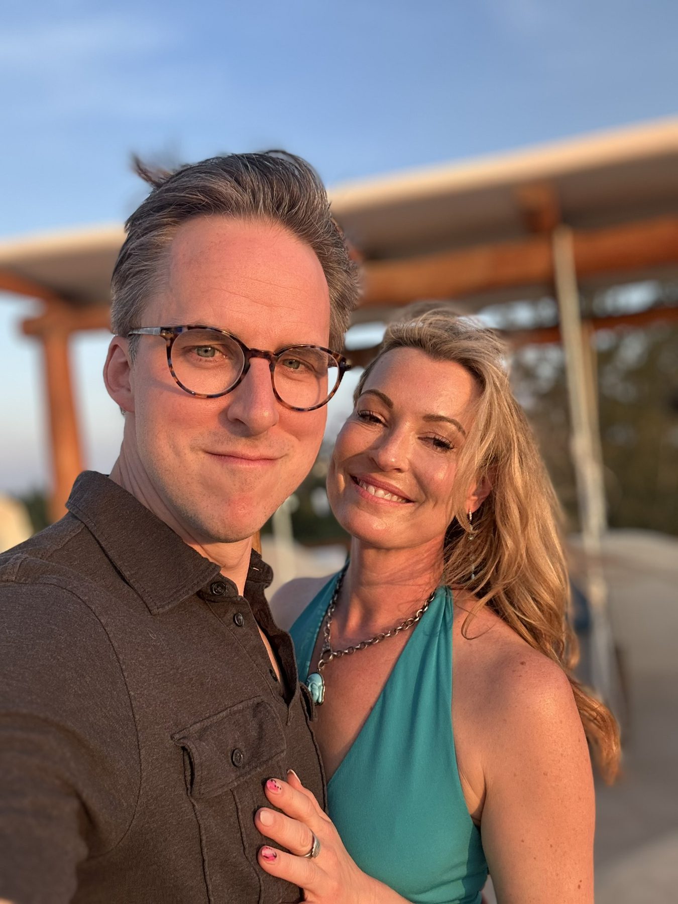Kimberly and Ian smiling close together in golden evening light