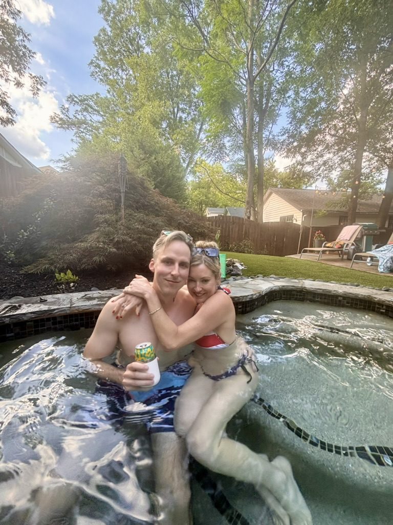 Kimberly and Ian hugging in a backyard hot tub